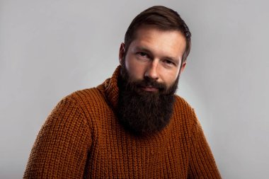 Genç kalın sakallı adam stüdyo portre çekim uzun. Sıcak örme kazak yakışıklı. Uzay koyu gri arka plan kopyalama