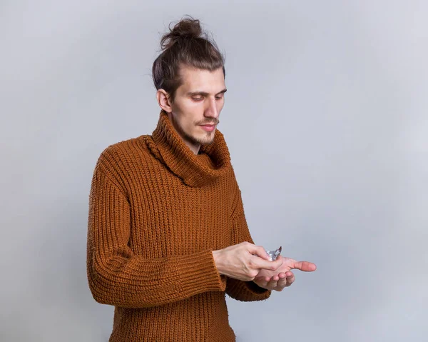 Man with pills in a warm knitted sweater. Dieting pill and vitamin. Cold, flu and headache treatment, hypnotic tablet. Health and medicine, hangover. Drug and antidepressant, insomnia.