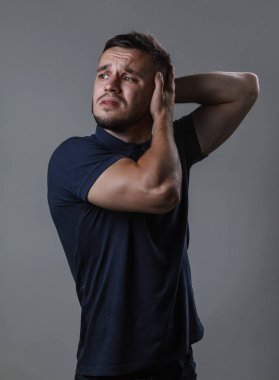 Bir kıl yaşamalı aşırı iş yükü nedeniyle boğaz boyun. Adam işçi gri bir arka plan kopya alanı üzerinde iki eliyle onun boyun masaj kneads