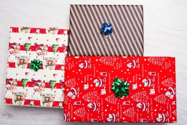 Beyaz ahşap zemin üzerinde üstten görünüm hediye kutuları. Xmas kağıt hediye yay ile dekore edilmiştir. Görünümünün kopya alanı ile üst Noel kavramı.