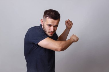 Deli ya da deli kötü göz ve mücadele kavramı için hazır. Kavga poz ya da bir şey tutan adam portresi ve yapar salıncak yumruk için. Jest gri arka plan kopya alanı üzerinde mücadele