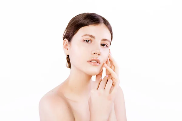 Vacker ung brunett kvinna med ren frisk hud rör eget ansikte. Ansiktsbehandling. Kosmetologi, skönhet och spa. Isolerad på en vit bakgrund — Stockfoto