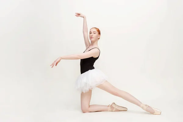 Jonge en ongelooflijk mooie ballerina is poseren en dansen in een licht grijze studio vol licht. De foto weerspiegelt sterk de onvergelijkbare schoonheid van een klassieke ballet kunst. Ruimte kopiëren — Stockfoto