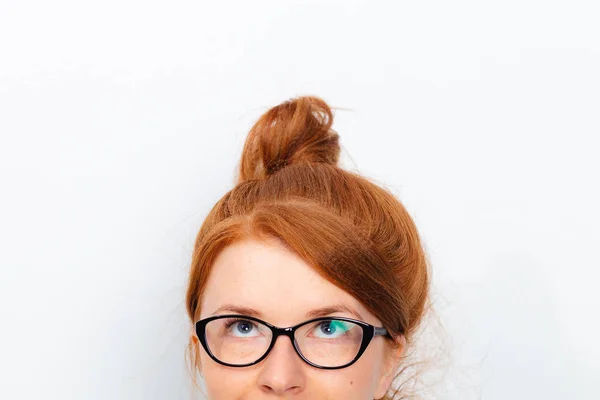 Gözlüklü genç kızıl saçlı bir kızın yarı portresi yukarı bakıyor — Stok fotoğraf