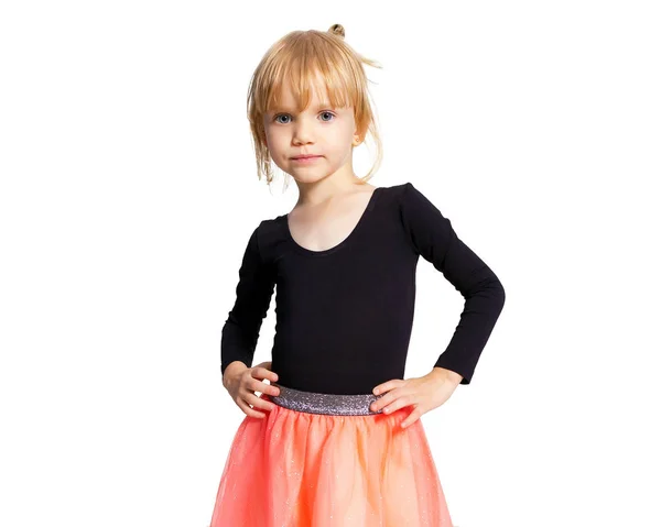 Kleines blondes Ballerina-Mädchen posiert im Tanzclub mit Holzboden und weißer Wand. junge Balletttänzerin in rosa Tutu, die Spaß hat und lächelt. Hintergrund, Kopierraum. — Stockfoto