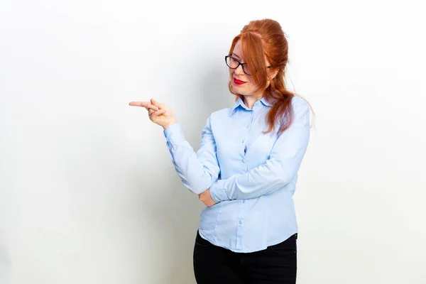 Portrait of young business woman pointing at white background. Copy space — ストック写真