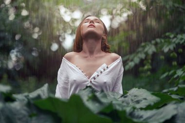 Yeşil yapraklı kadın doğanın tadını çıkarıyor. Sağlıklı, parlak, pürüzsüz ve doğal yeşil palmiye yaprağı olan güzel bir kadının portresi.