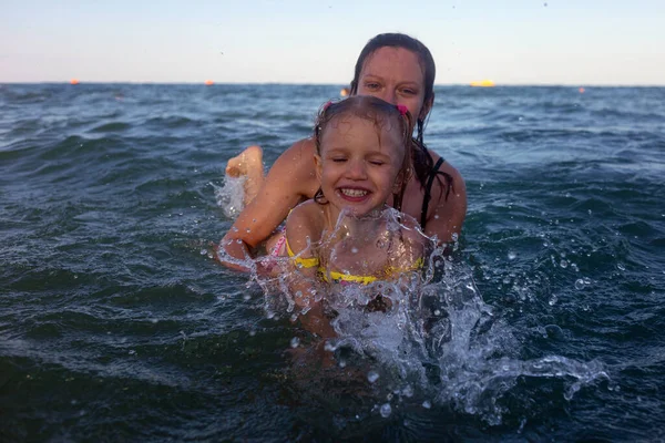 Mamá Está Sosteniendo Pequeña Hija Bañan Mar Muchas Gotas Spray — Foto de Stock
