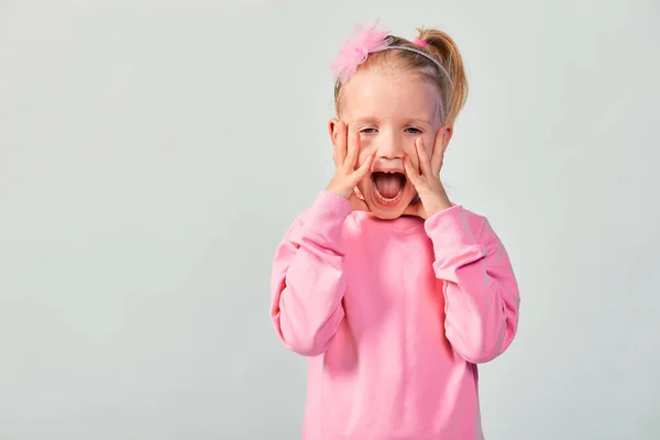 可愛いです女の子4 5歳作ります驚き顔でスタジオでピンクスウェットシャツ — ストック写真