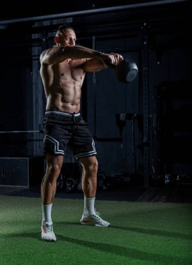 Ağırlıklarla antrenman yapan kaslı adam. Güçlü atletik adam egzersiz yapar. Vücut geliştirme uzmanı spor salonunda egzersiz yapıyor..