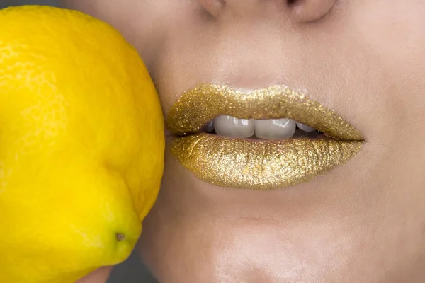 Vacker närbild med kvinnliga läppar med guldfärgad makeup och citron. Glitter kosmetika — Stockfoto