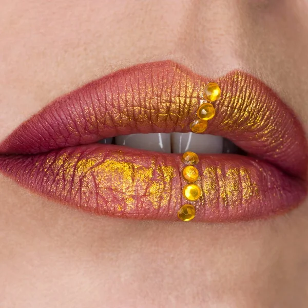 Lábios femininos bonitos fechar. Batom vermelho, tinta dourada. Joalharia em lábios — Fotografia de Stock
