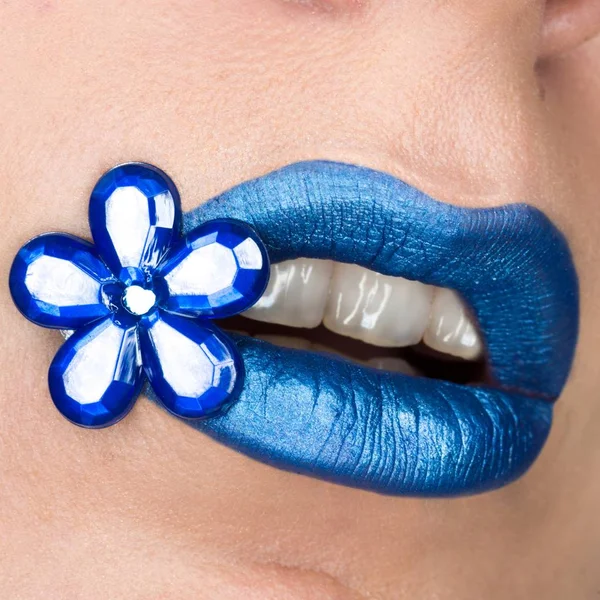 Visão de perto de lábios de mulher bonita com batom azul. Boca aberta. Cosmetologia, maquiagem de moda. Flor de jóias — Fotografia de Stock