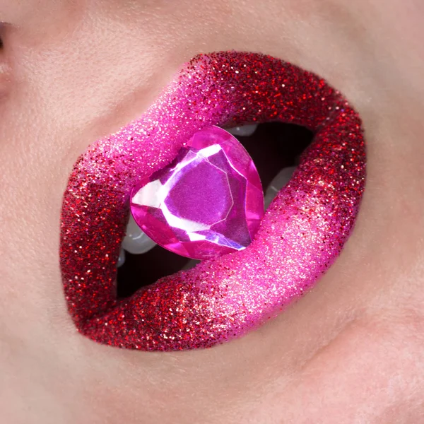 Red pink lips covered with sparkles and with diamong. Beautiful woman with red pink lipstick on her lips, open mouth