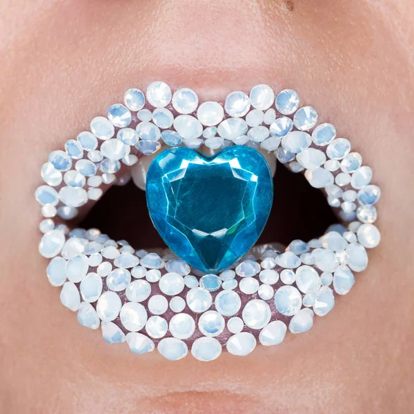 Vacker närbild med kvinnliga läppar med vita briljanter och blå lysande i munnen. Smink, glitter gnistrar på läpp — Stockfoto
