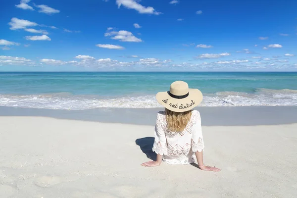 Woman sits on ocean beach in Cuba, wearing hat, beautiful sky and water, Do not disturb, perfect background, free space — Stock Photo, Image