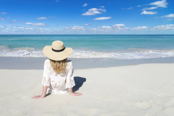 Молодая женщина в шляпе отдыхает на пляже. Белый песок, голубое облачное небо и хрустальное море тропического пляжа. Куба, Varadero — стоковое фото