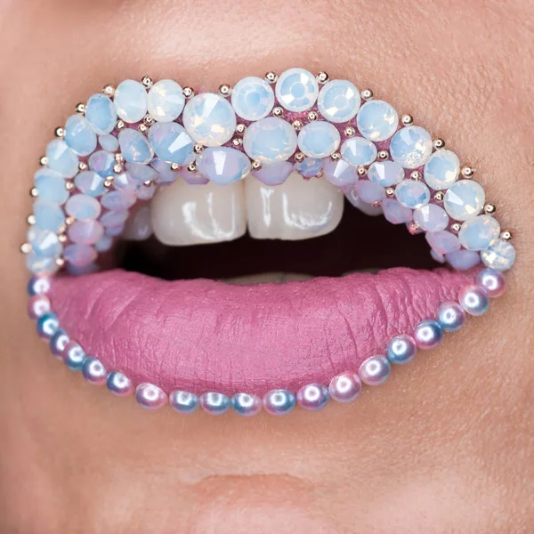 Fechar-se de belos lábios cor-de-rosa com pedras brancas e dentes brancos. Batom mate rosa. Maquiagem, Cosméticos, arte de lábios — Fotografia de Stock