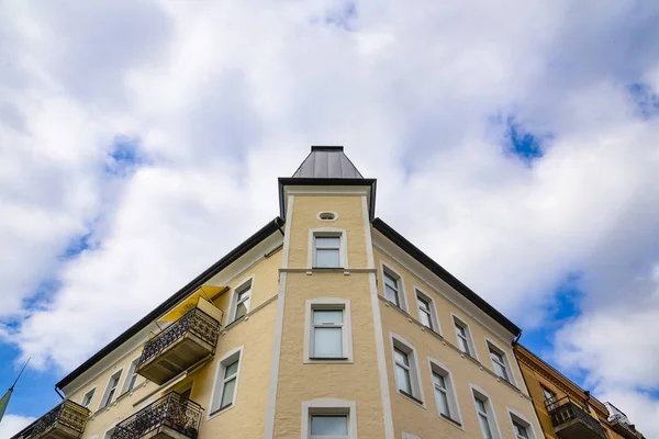 Dwelling house in Sweden. View of top corner of the house from the bottom stread road. Windows and balconies with awning