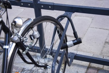 Bisiklet, bisiklet park alanındaki U-Lock 'tan güvenli bir şekilde kilitlenmiş. Ön tekerleğin arka sağ tarafı. Güvenlik, çalıntı bisiklet.