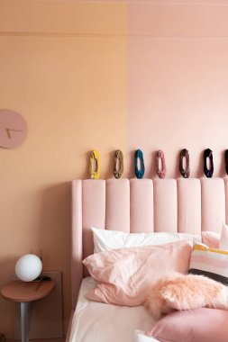 Yatak için başlık üzerinde renkli ayakkabılar ile açık pembe yatak odası iç