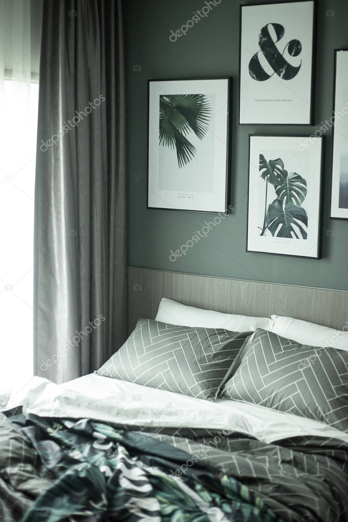 Light bedroom interior in green colors and cozy bedclothes