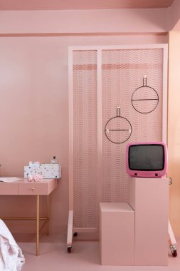 Vintage tv, kadife sandalye ve kozmetik masa ile şık pembe iç 