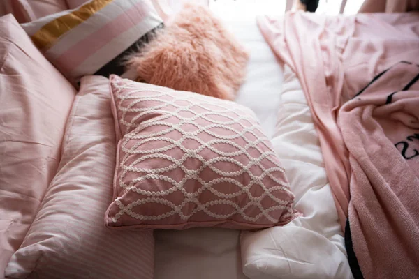 close up of pillows on bed in pastel color