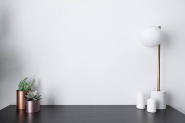 oturma odasında dekorasyon olarak yapay bitkiler, mumlar ve lamba 