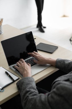 İş adamı, ahşap masa üzerinde ofis aksesuarları olan bir dizüstü bilgisayarda bilgi yazarken. İş ve teknoloji kavramı / Kopyalama alanı