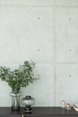 Cam vazodaki suni bitki, ahşap çalışma masasının üzerinde beton duvar arkaplanı / apartman içi / kopyalama alanı ile çalışıyor.