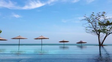 Sonsuz kenar havuzu arka planda mavi deniz ve berrak gökyüzü görüntüsü / seyahat konsepti ile tatil beldesinde