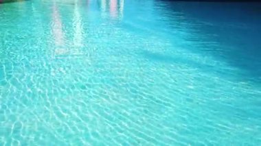 Doğal ışık görüntüsü / arkaplan dokusu / 4k çözünürlüğüyle havuzda berrak turkuaz suyun yansıması