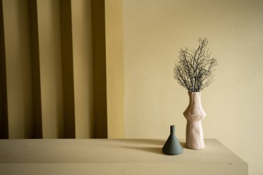 Yatak odası köşesinde pembe ve mavi seramik vazo var.