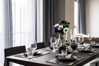 Altın paslanmaz sofra takımı ile yemek masası seti olan ev içi. Anlamsal mermer üst / iç tasarım üzerine kurulmuş siyah çatal bıçak seti.