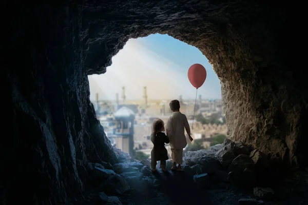 洞窟に立つ風船を持つ小さな女の子と少年 — ストック写真