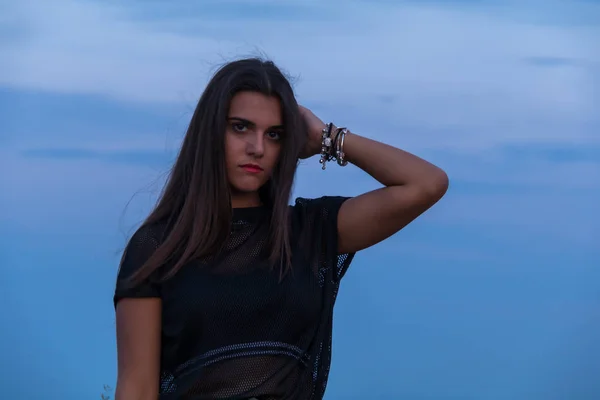 Hermosa joven morena posando una carretera en medio del campo al atardecer — Foto de Stock