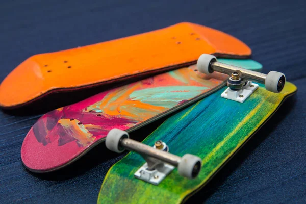 Miniaturní dřevěná skateboard hračka na modrém dřevěném pozadí — Stock fotografie
