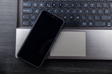 Granada, İspanya, 10 Ocak 2019: Modern dizüstü bilgisayar ve akıllı telefon, Çift kameralı ve parmak izi okuyuculu mobil. Xiaomi Mi A2