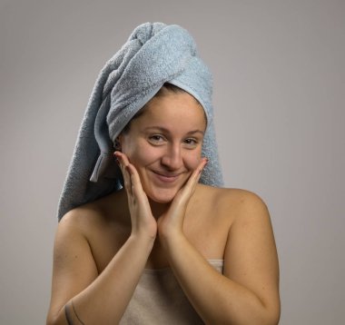 Bir havlu ve gülümseyerek duş sonra Kız. Yüzüne dokunmak