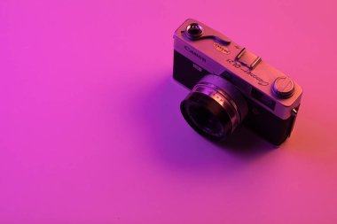 vintage kamera pembe arka plan ve mor ışık izole. Kopyalama alanı