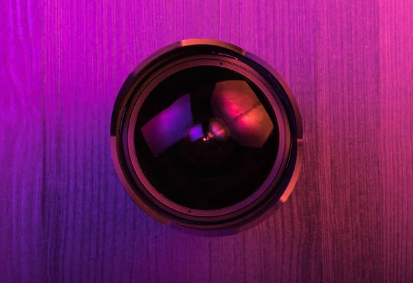 Fischaugenlinse. Rosafarbenes Licht. Arbeitsbereich von oben. Holz Hintergrund — Stockfoto