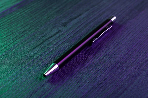Елегантна ручка на фоні дерева і зелене і синє світло. Бізнес чорна ручка. Вид зверху — стокове фото