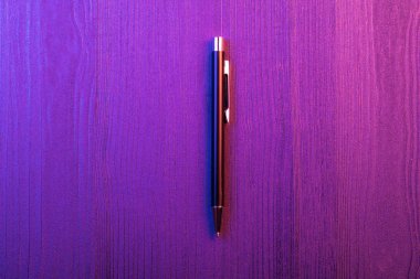 Ahşap arka plan ve mor ve pembe ışık zarif kalem. İş siyah kalem. Üstte görüntü