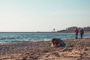 kızıl saçlı kız sarılma ve sahilde köpeğini kurutma. Punta Entina en Almerimar, Almeria, Endülüs, İspanya