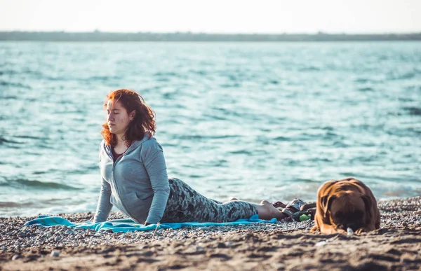 Menina fazendo ioga e alongamento na praia — Fotografia de Stock