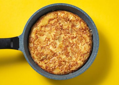 sarı arka plan üzerinde tava üzerinde tortilla de patatas, tipik İspanyolca çanak.