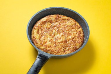 sarı arka plan üzerinde tava üzerinde tortilla de patatas, tipik İspanyolca çanak.