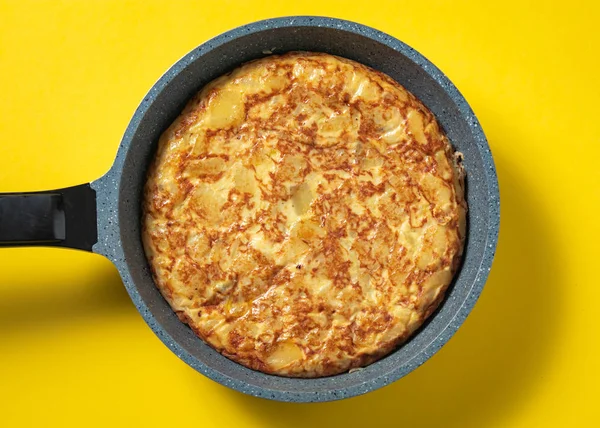 sarı arka plan üzerinde tava üzerinde tortilla de patatas, tipik İspanyolca çanak.