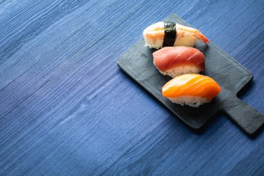 Nigiri suşi bir Japon restoranında ahşap masada. Alanı ve üst görünümü kopyalama